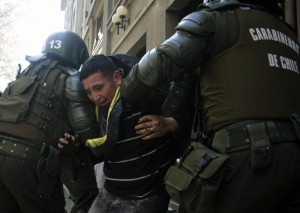I carabineros fermano uno studente durante le proteste di Santiago del Cile